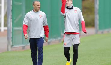 Arsenal's Mikael Silvestre, left, and Nicklas Bendtner walk to the pitch during their training session